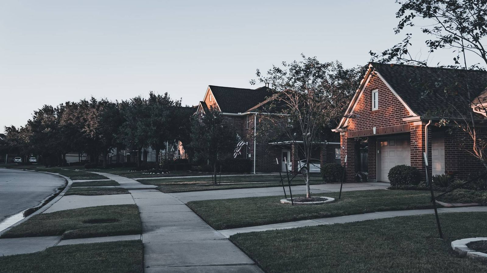 Brick houses with lawns along a curving sidewalk